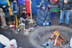 Activists offering thanks of sage, fir nettles, and tobacco to the sacred fire - photo by C.S. Hagen