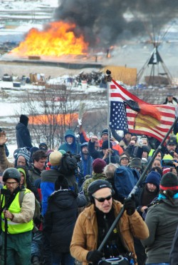 Activists at Oceti entrance while fires rage behind them - photo by C.S. Hagen