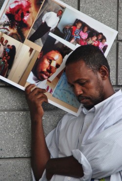  Makruun Hagar with a poster of injuries suffered after an attack - photo by C.S. Hagen