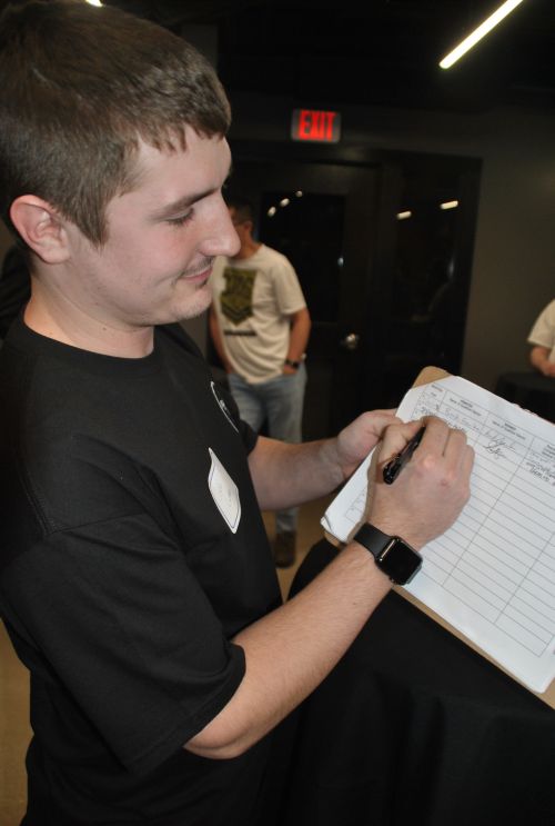 Justin Ludtke, from Mandan, preparing to sign petition - photograph by C.S. Hagen