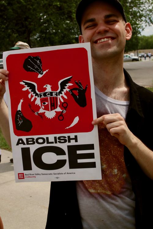 Jacob Scott, from Fargo, holds up a Red River Valley Democratic Socialist of America sign - photograph by C.S. Hagen