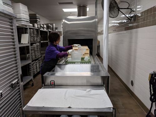 Trays and supplies moving through the sanitizer