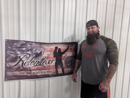 Marshall johnson standing next to a Relentless poster with his and Carter's image