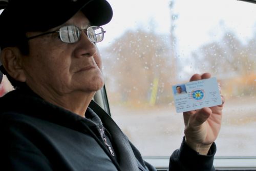 Dale Brave Crow holds up his Standing Rock Sioux Tribe ID card - photograph by C.S. Hagen