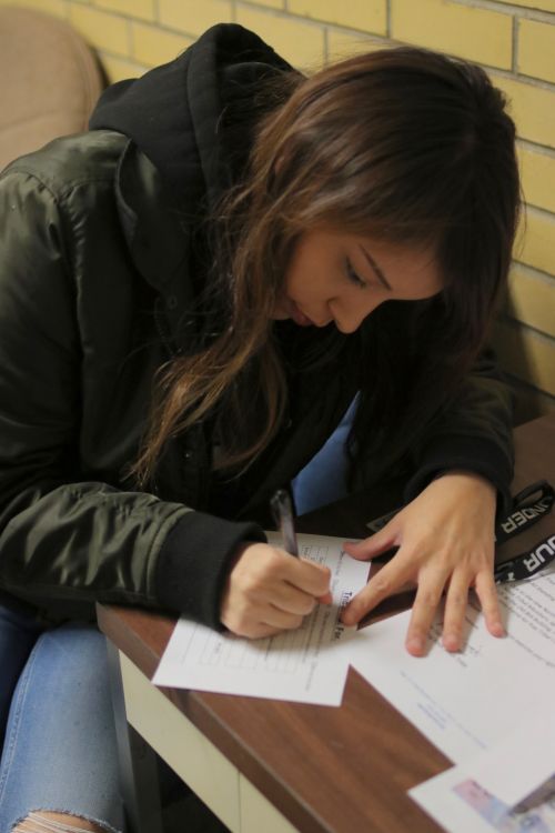 Shaye Eagle Shield, a member of the Standing Rock Sioux Tribe, fills out a Tribal I.D. Form - photograph by C.S. Hagen