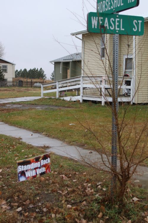 Standing Rock will vote sign beneath Weasel Street and Horseshoe Road in Cannon Ball - photograph by C.S. Hagen