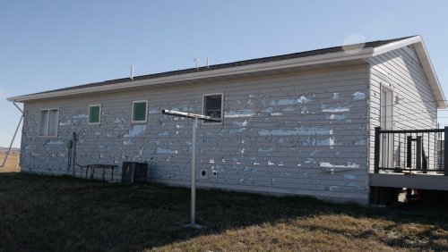 Hail damaged siding with windows already replaced in Pine Ridge, SD - video screenshot by Charles Banner