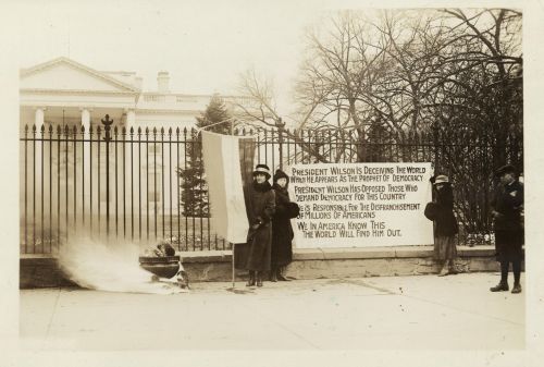 National Woman's Party watchfire demonstrators standing with banners and fire in urn in front of White House during the early 1900s - Harris & Ewing, Washington, D.C