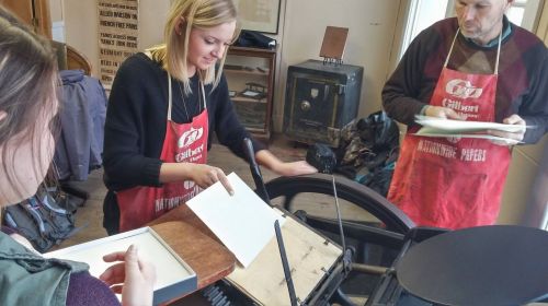 Students learning to operate letterpress equipment - photograph by Suzzanne Kelley