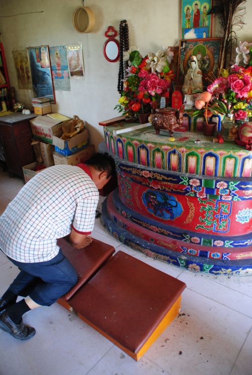 Wang Xinxin showing reverence at the fox altar - photograph by C.S. Hagen