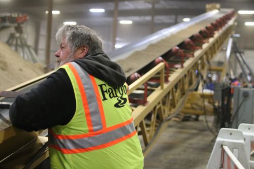 City of Fargo employee watching conveyor belt for clumps - photograph by C.S. Hagen