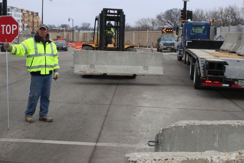 City of Fargo employees work to buffer steel wall over First Avenue North as the Red River creeps closer - photograph by C.S. Hagen