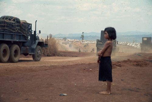 A Montagnard child watches the convoy moving toward Plei Djerang. The convoy is carrying men and equipment to the armed assault -  Specialist Christopher Childs May 14 1970 National Archives Records of the Office of the Chief Signal Officer