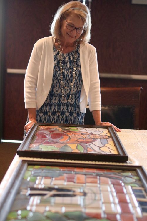 Bonanzaville Executive Director Brenda Warren looks over the Great Depression era mosaics made from North Dakota clay that will be on display and priced during the Antique Road Show - photograph by C.S. Hagen