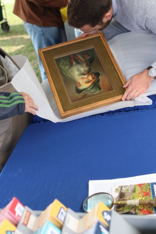 Antique Roadshow appraiser inspecting a painting - photograph by C.S. Hagen