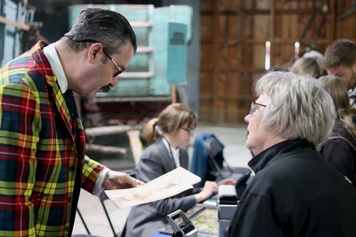 Appraiser Nicholas Lowry investigating a print - photograph by C.S. Hagen