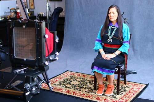 New Mexico Representative Debra Haaland sitting for a wet plate photograph with Shane Balkowitsch in viewfinder - photograph by C.S. Hagen