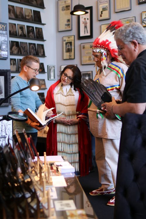 South Dakota Representative Tamara St. John - center - looking at a book by photographer Edward Curtis with Shane Balkowitsch - photograph by C.S. Hagen