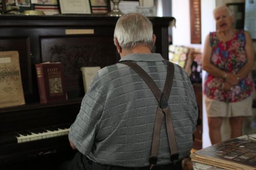 Victor Wald playing old German Russian song on piano while his wife, Barb Wald, sings - photograph by C.S. Hagen