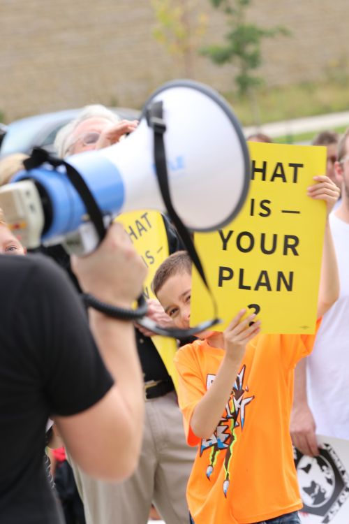 A young child holding up a sign to raise awareness on climate change - photograph by C.S. Hagen