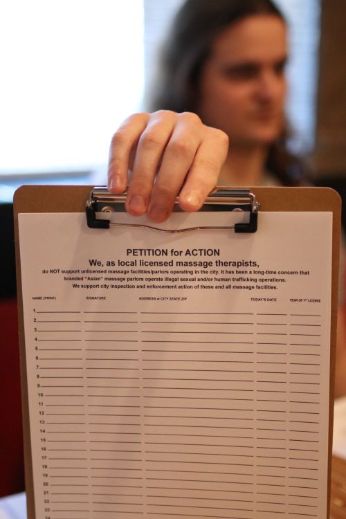 Keith Coates holds up petition that will work its way to the state legislature to stop human trafficking - photograph by C.S. Hagen