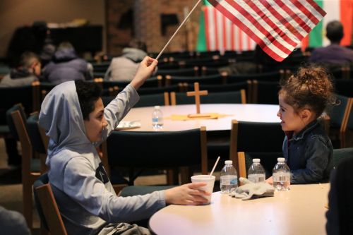 Young boy waves an American flag - photograph by C.S. Hagen