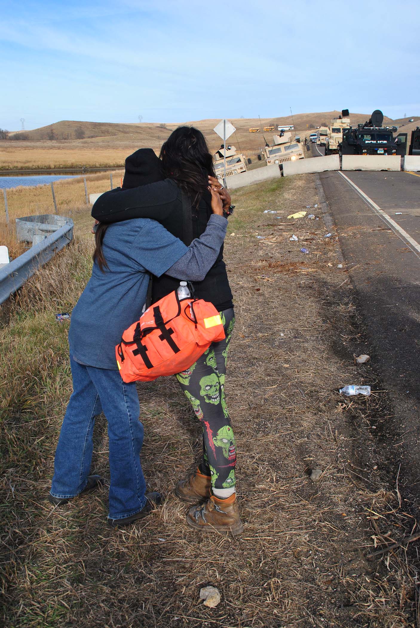 Actibists hugging each other as law enforcement prepare to march - photo by C.S. Hagen