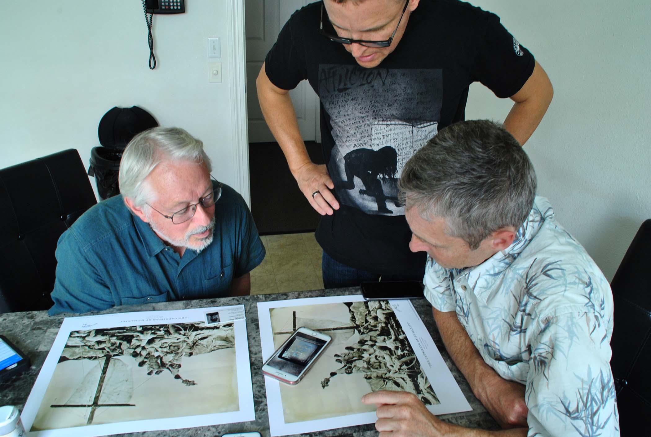 Michael Foster and Leonard Higgins, both valve turners, discuss a wet plat photograph event with Bismarck native Shane Balkowitsch - photo by C.S. Hagen