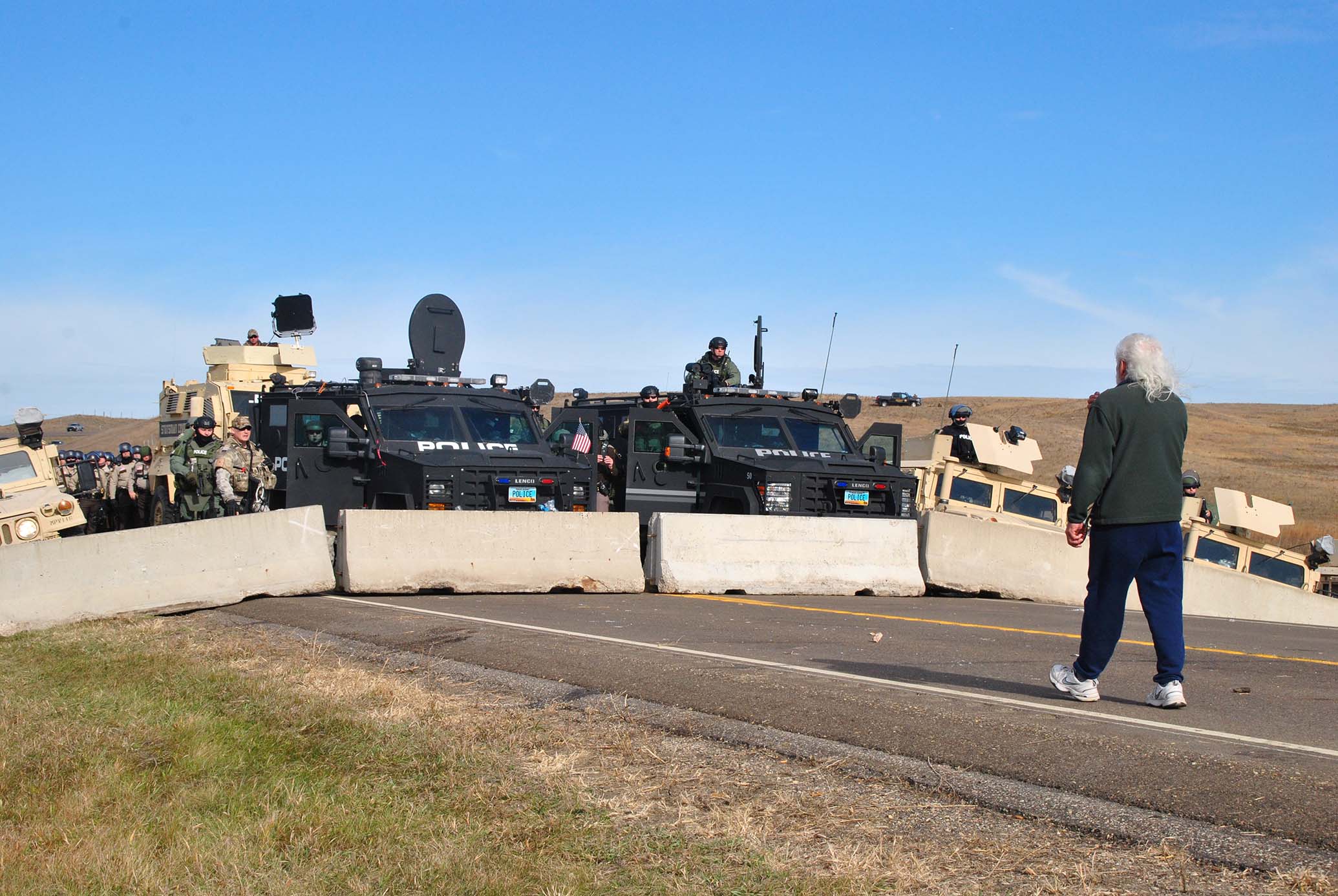 Standing Rock elder Miles Davis approaching the police line - photo by C.S. Hagen