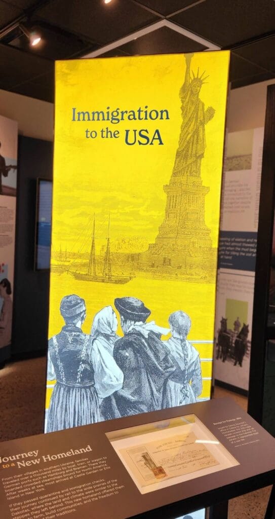 Yellow "Immigration to the USA" panel with the Statue of Liberty and German-Russian immigrants at the Germans from Russia Heritage Collection exhibit at NDSU